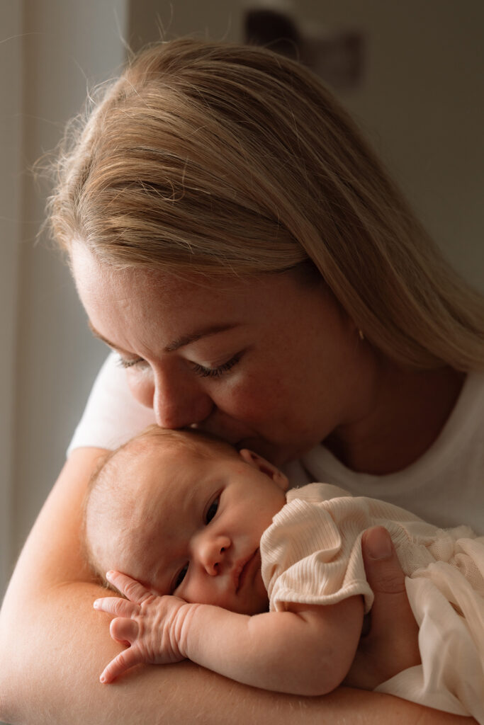 Moeder met pasgeboren baby tijdens een newbornshoot